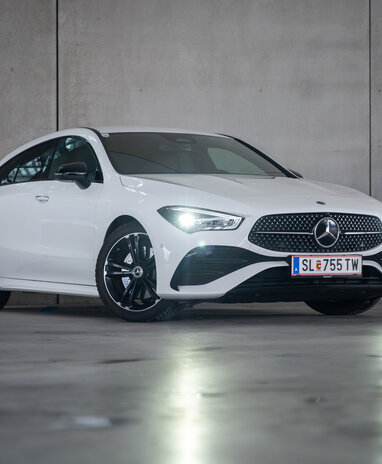 Weißer Mercedes-Benz CLA Shooting Brake, geparkt vor einer Betonwand.
