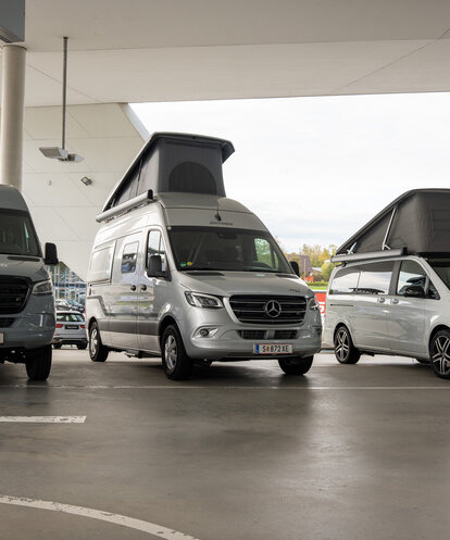 Drei geparkte Mercedes Camper Vans mit ausgefahrenen Aufstelldächern.