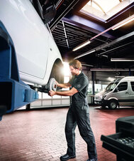 Ein Mechaniker arbeitet an einem Mercedes-Benz in der Werkstatt.