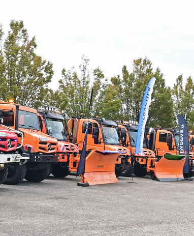 Viele Kommunalfahrzeuge stehen nebeneinander aufgefädelt auf einem großen Platz.