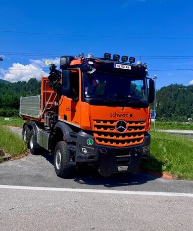 Orangefarbener Mercedes-Benz Arocs der Silberstadt Schwaz mit einem Kipperaufbau.