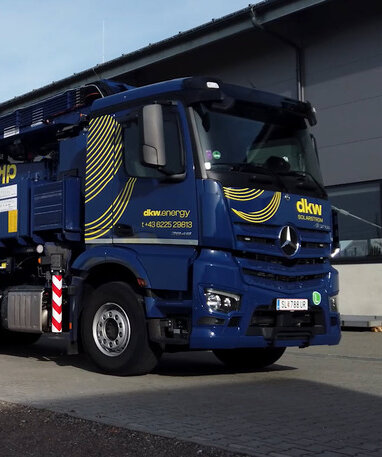 Mercedes-Benz Actros mit Pritschenaufbau im Branding von dkw Solarstrom.