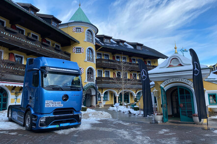 Blauer Mercedes-Benz Lkw Actros 600 vor einem Hotel im Winter.
