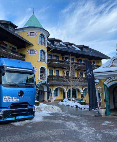 Blauer Mercedes-Benz Lkw Actros 600 vor einem Hotel im Winter.