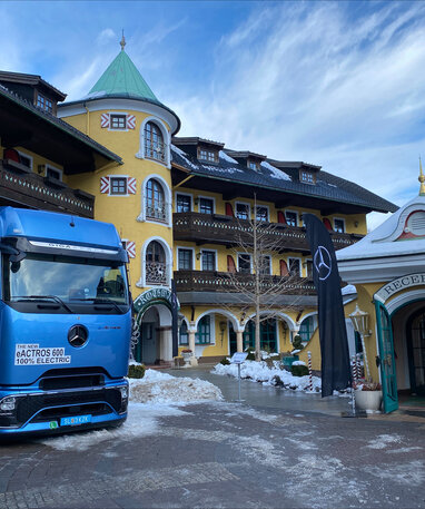 Blauer Mercedes-Benz Lkw Actros 600 vor einem Hotel im Winter.