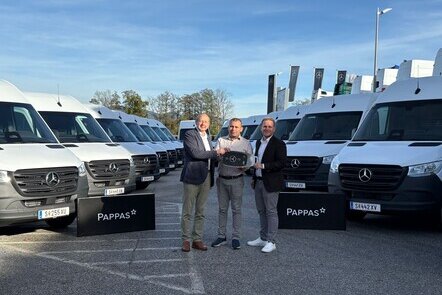 Johann Wieser und Rene Böckl von Pappas Eugendorf übergeben symbolisch einen großen Autoschlüssel an NA Logistik GmbH Inhaber Herrn Niazi. Im Hintergrund stehen mehrere weiße Mercedes-Benz Sprinter.