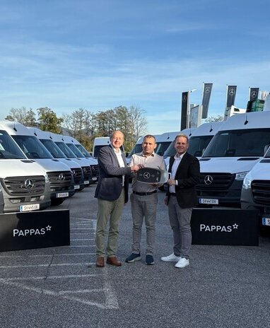 Johann Wieser und Rene Böckl von Pappas Eugendorf übergeben symbolisch einen großen Autoschlüssel an NA Logistik GmbH Inhaber Herrn Niazi. Im Hintergrund stehen mehrere weiße Mercedes-Benz Sprinter.