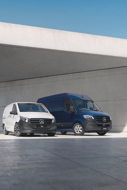 Ein weißer Mercedes-Benz Vito und ein dunkelblauer Sprinter stehen nebeneinander. 