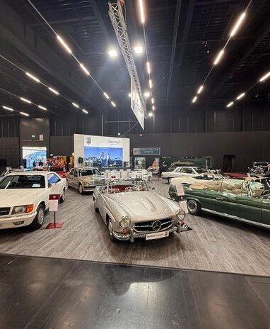 Mercedes-Benz Oldtimer-Ausstellung in einer Halle mit mehreren Modellen, darunter Cabriolets und Coupés.
