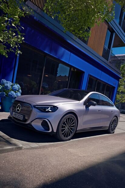 Mercedes-Benz Auto parkt auf einer städtischen Straße vor einem blauen Gebäude, umgeben von Pflanzen. | © Mercedes-Benz AG
