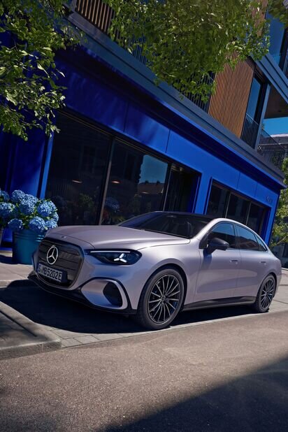 Mercedes-Benz Auto parkt auf einer städtischen Straße vor einem blauen Gebäude, umgeben von Pflanzen. | © Mercedes-Benz AG