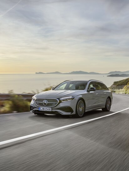 Mercedes-Benz E-Klasse T-Modell fährt auf Küstenstraße bei Sonnenuntergang.