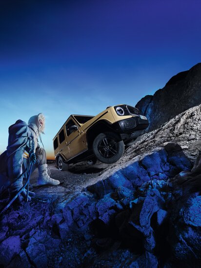 Ein Mercedes-Benz G-Klasse elektrisch erklimmt einen steilen Berg im Abendlicht.