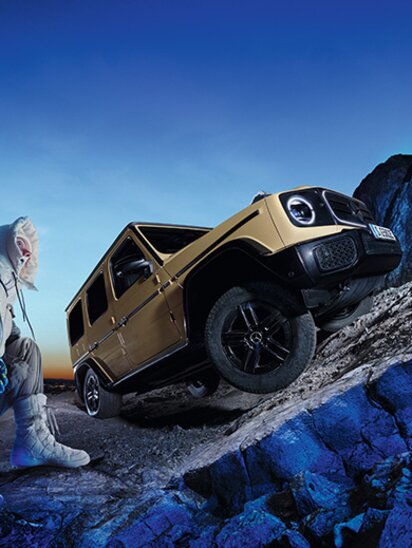 Eine Mercedes-Benz G-Klasse elektrisch fährt einen steilen Hang hoch.