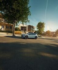 Ein Mercedes-Benz GLA steht in einer modernen Wohnstraße bei Sonnenschein. | © Mercedes-Benz