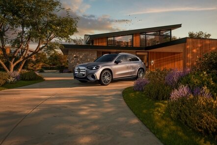 Ein silberner Mercedes-Benz GLC elektrisch steht vor einem modernen Haus mit Garten. | © Mercedes-Benz AG