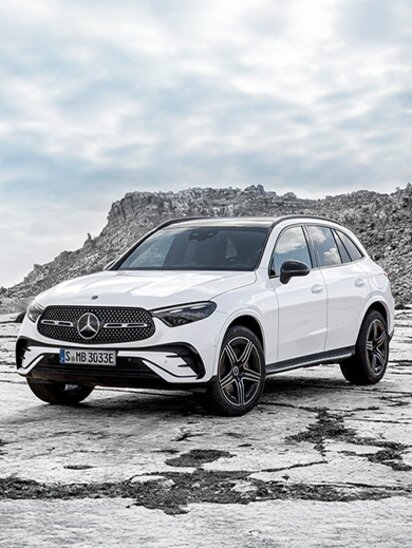 Weißer Mercedes-Benz GLC auf felsigem Terrain mit bewölktem Himmel.