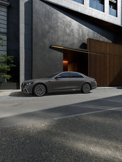 Graue Mercedes-Benz S-Klasse parkt vor einem modernen Gebäude aus Beton und Holz, seitlich fotografiert. | © Mercedes-Benz Group AG