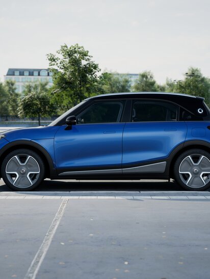 Blauer smart #1 auf einem Parkplatz, seitlich fotografiert.