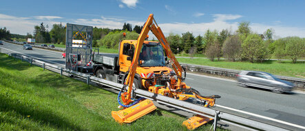 Unimog U 323 mit Mähanbau für Mäharbeiten an einer Autobahn.